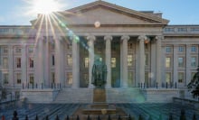 The sun flares over the headquarters of the U.S. Treasury