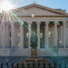 The sun flares over the headquarters of the U.S. Treasury