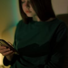 A teen girl looks at her phone.